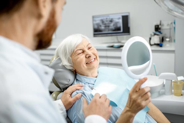 older woman smiling after same day dentures from Jeanette Thai, DDS in Lake Forest, CA